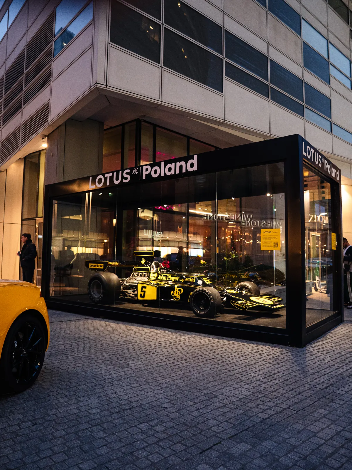 The Lotus Poland glass pavilion at Złota 44 with the Lotus Type 72 racing car in John Player Special livery, after dark
